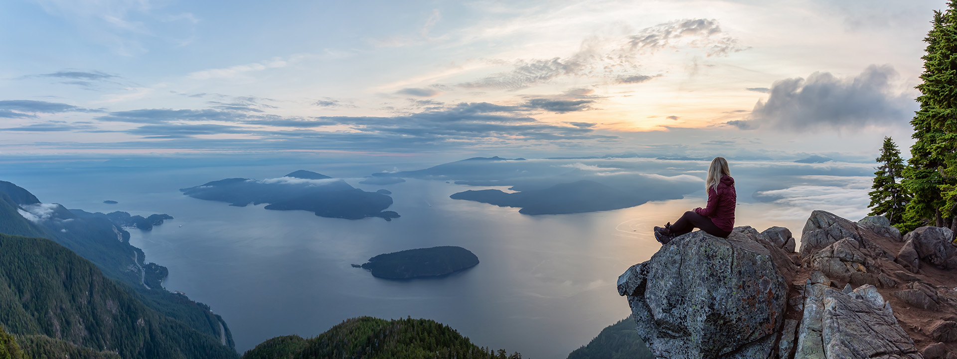 Jeune femme assise en au d'une montagne regardant l'horizon